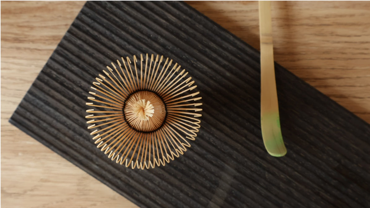 Bamboo matcha whisk on a dark ceramic tray